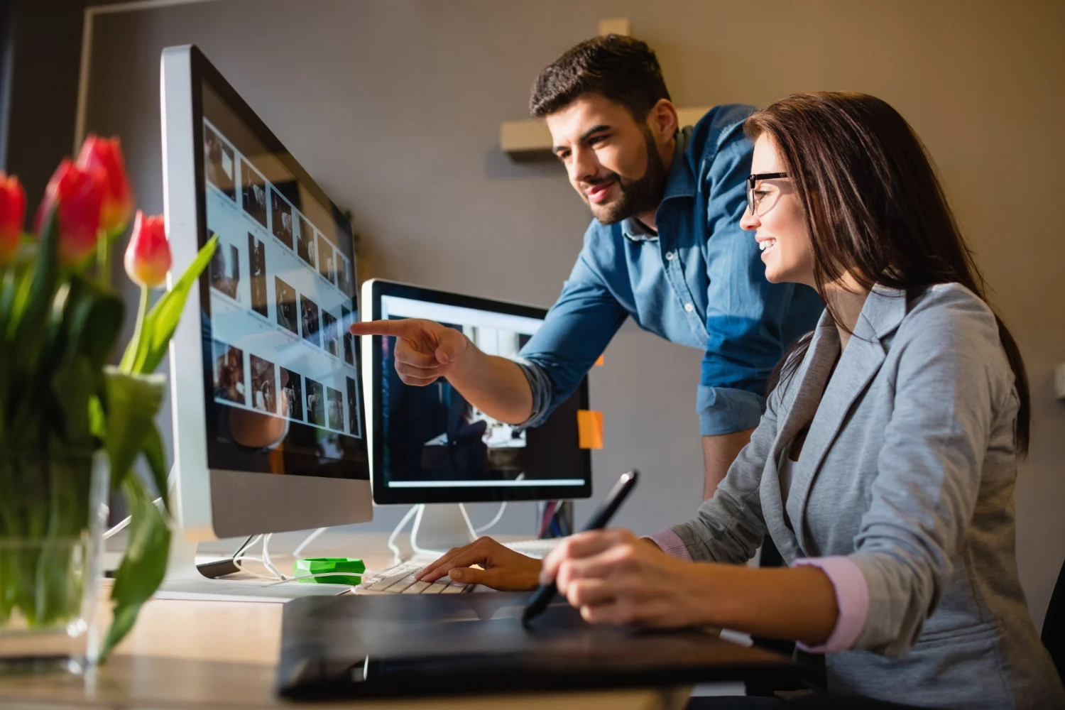 Two professional designers working on a high-fidelity B2B manufacturing website design, showcasing the benefits of a specialized industrial web design agency.