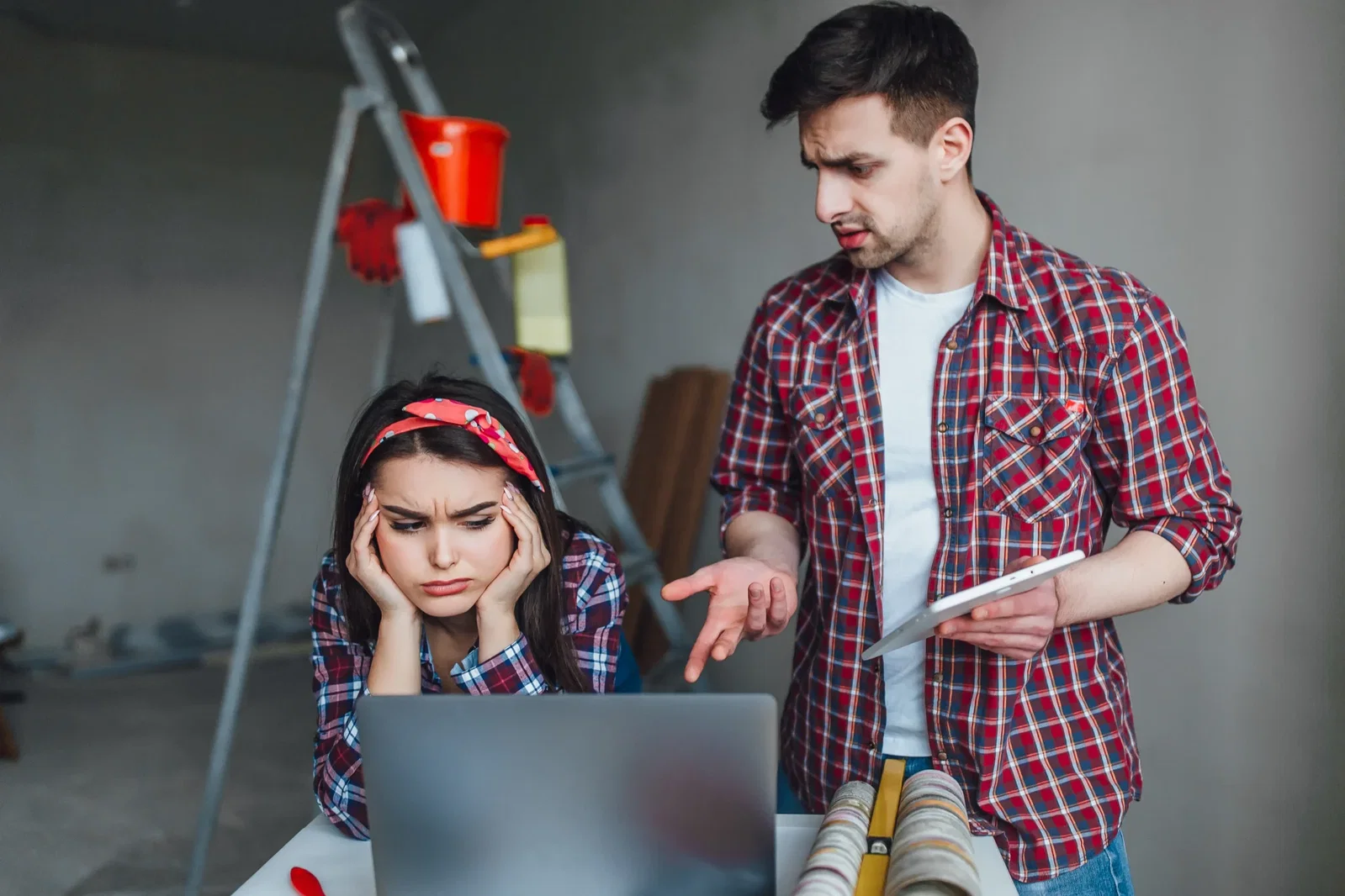 Frustrated business owners in a renovation setting struggling with a generic website, representing why generalist agencies fail heavy construction brands.