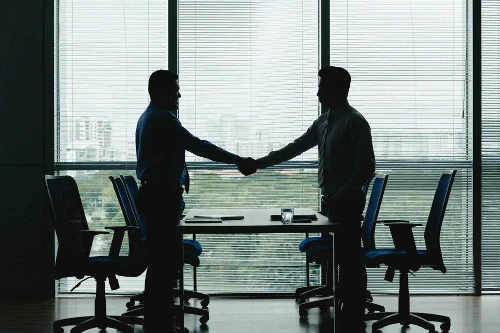 Professional handshake silhouette representing the client onboarding process at Pixerts B2B agency.